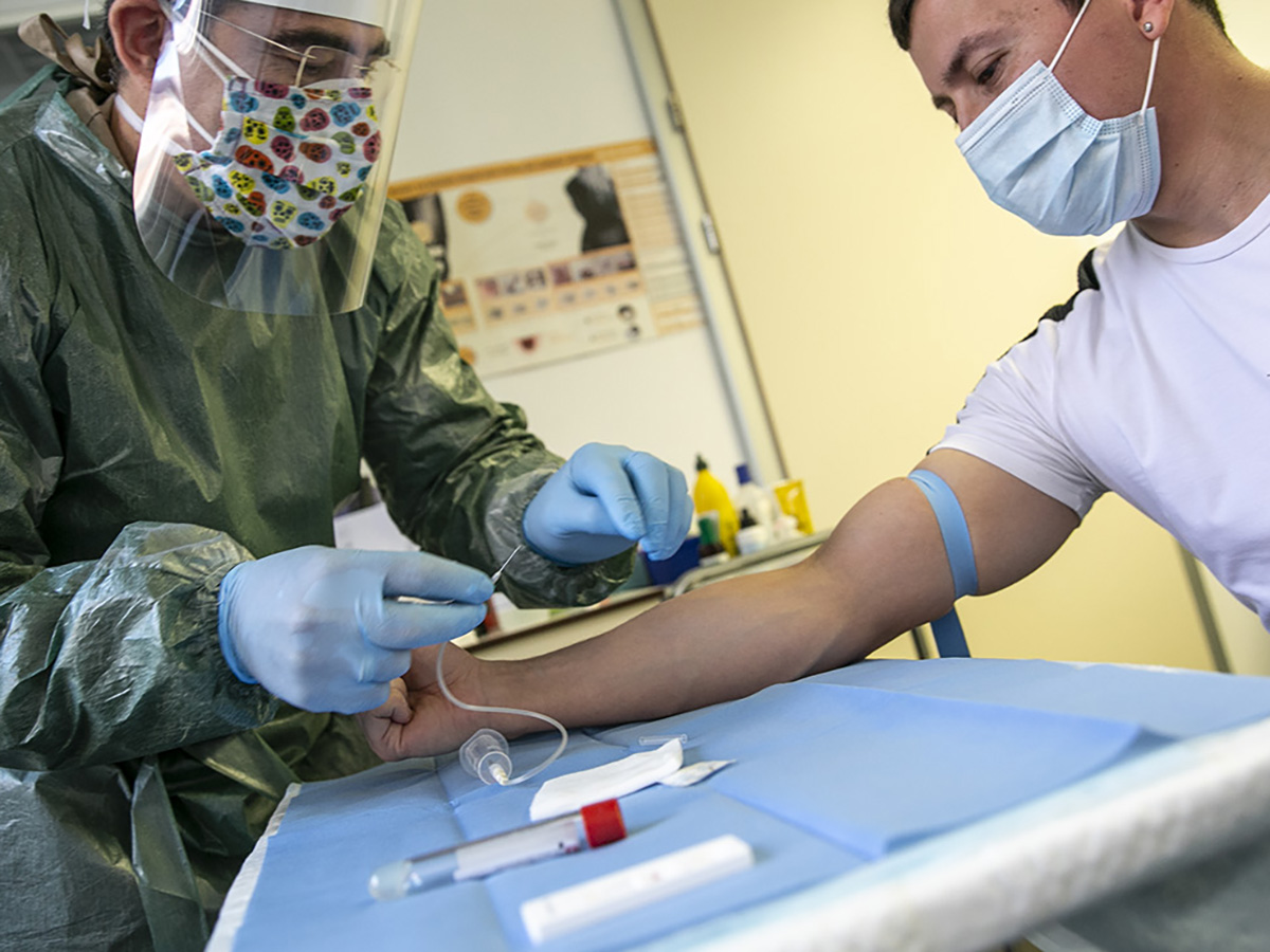Un enfermero de Atención Primaria toma una muestra de sangre de un joven en plena crisis del COVID 19