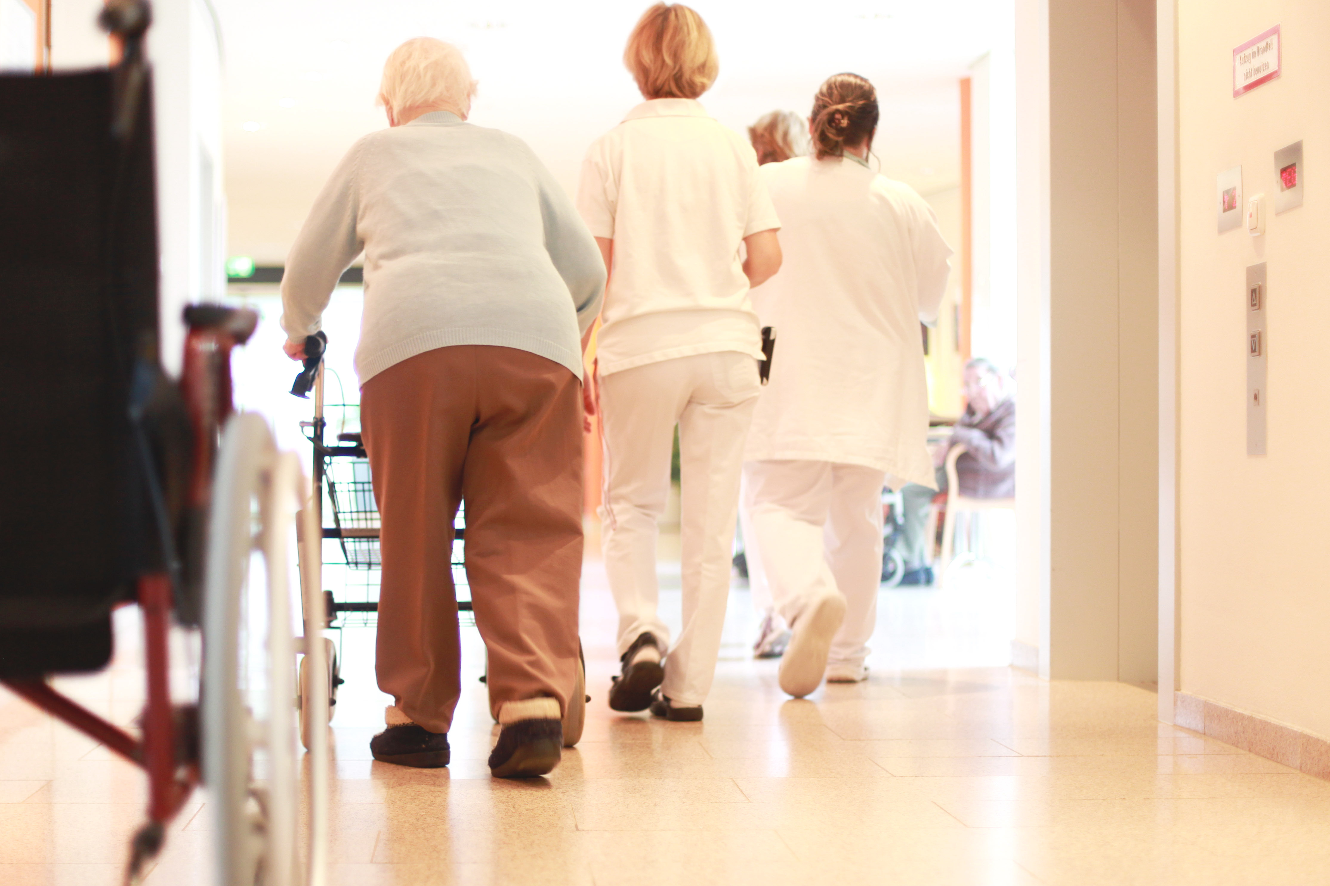 Pacient i infermeres en un passadís d'hospital