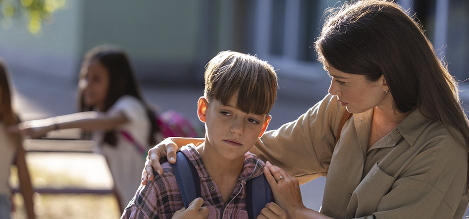 niño triste y su madre a la salida de la escuela