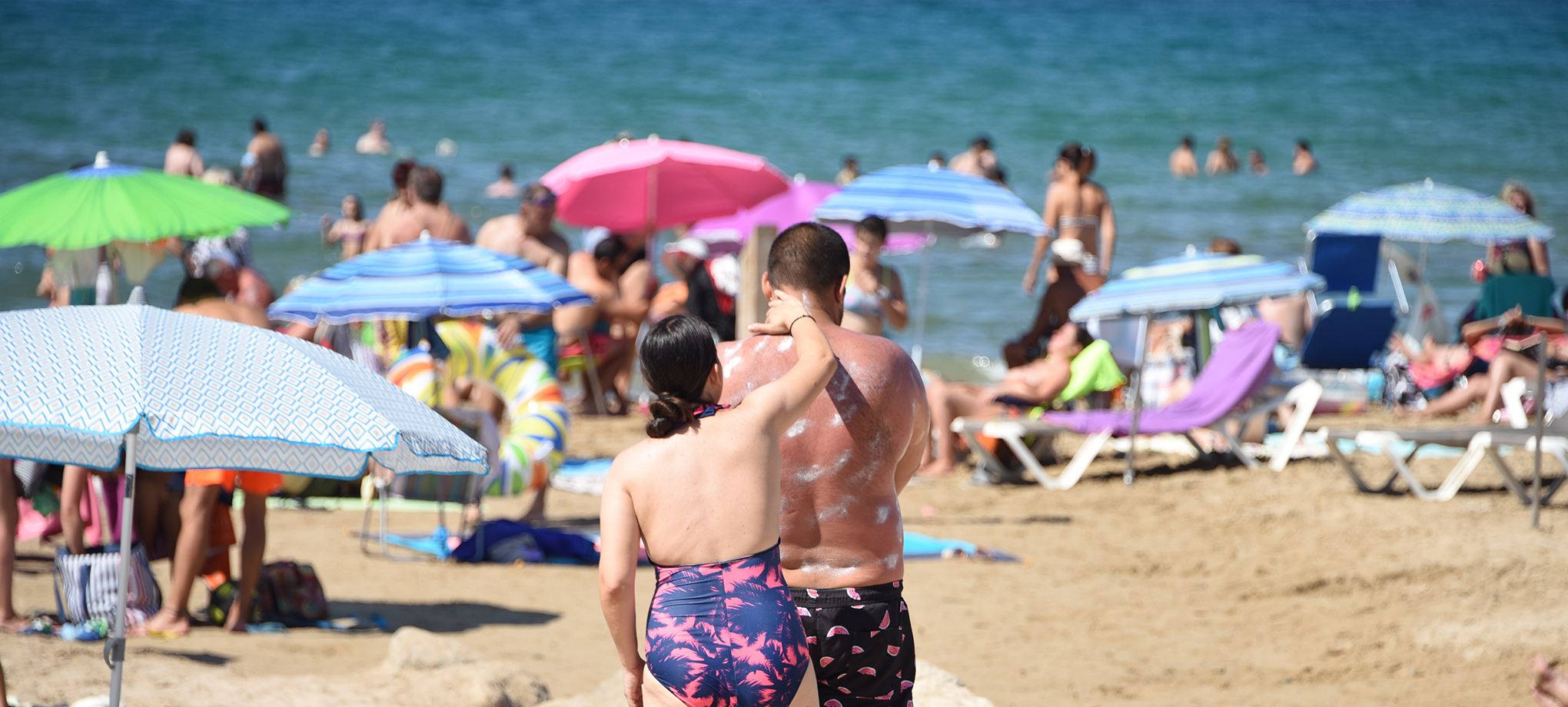 persones a la platja es posen crema